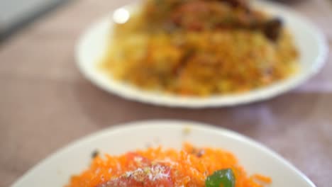 Close-up-of-Homemade-Zarda-and-Chicken-Sindhi-Biryani-served-on-a-white-plate,-selective-focus,-slow-motion