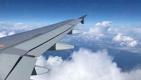 Flugzeugflügel-Fliegt-über-Weiße-Wolken-Und-Blauen-Himmel