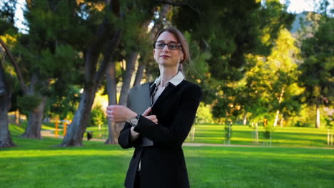 attractive caucasian business woman walks toward the camera, and looks at the camera with an expression of pride and confidence