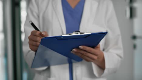 close up female doctor completes the medical documentation.