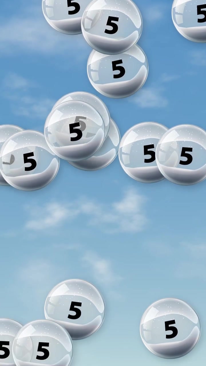 Transparent spheres containing the number five float and bounce against a blue cloudy sky background.
