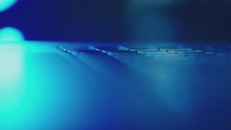 close-up of a laptop keyboard under blue light