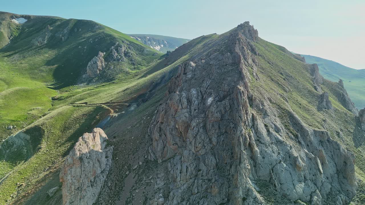 Aerial view of rugged mountain peaks under clear blue sky
