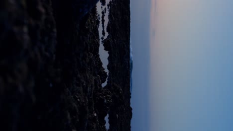 low angle shot of the suluban creek in bali during ebb tide at sunset with the sky reflected in the water
