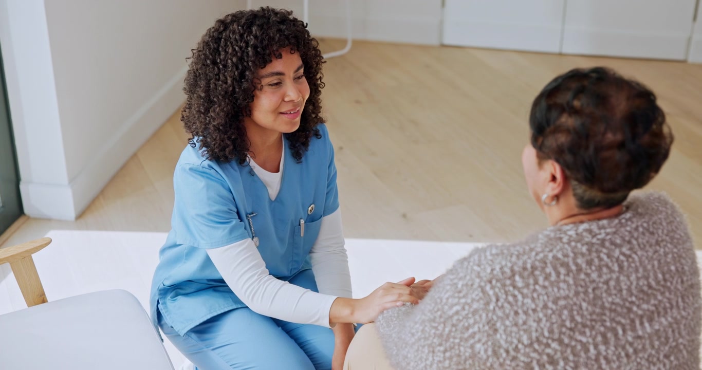 Compassionate Nurse Comforting Senior Patient During Home Visit