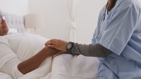 mixed race woman being visited at home by a nurse. social distancing and self isolation in quarantin