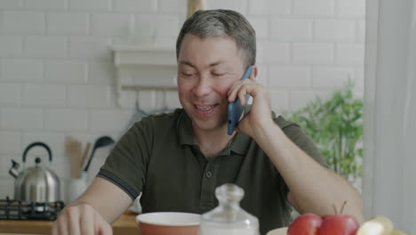 hombre hablando por teléfono en la cocina