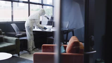 cleaners wearing protective clothes sanitizing modern office space