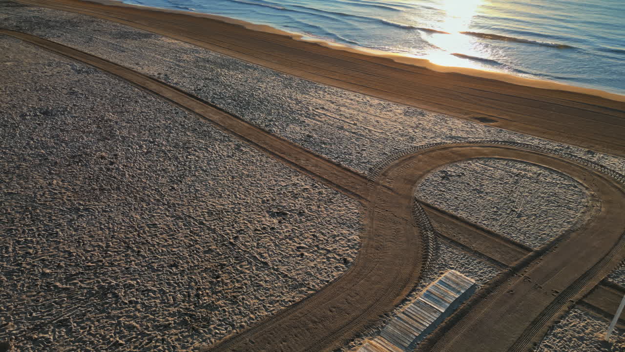 Aerial drone view of palm trees on the beach in Alicante, Spain at sunset