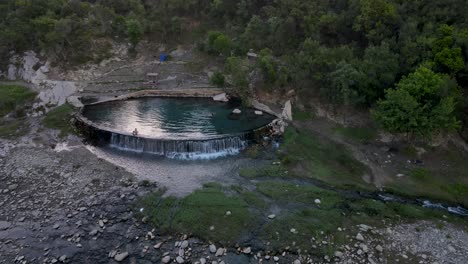 aerial orbit view of people having fun in permet hot springs, albania - cinematic footage