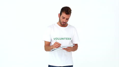handsome volunteer writing on notepad