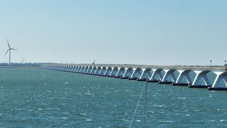 fast long lens drone shot of the famous zeeland bridge during a sunny autumn day