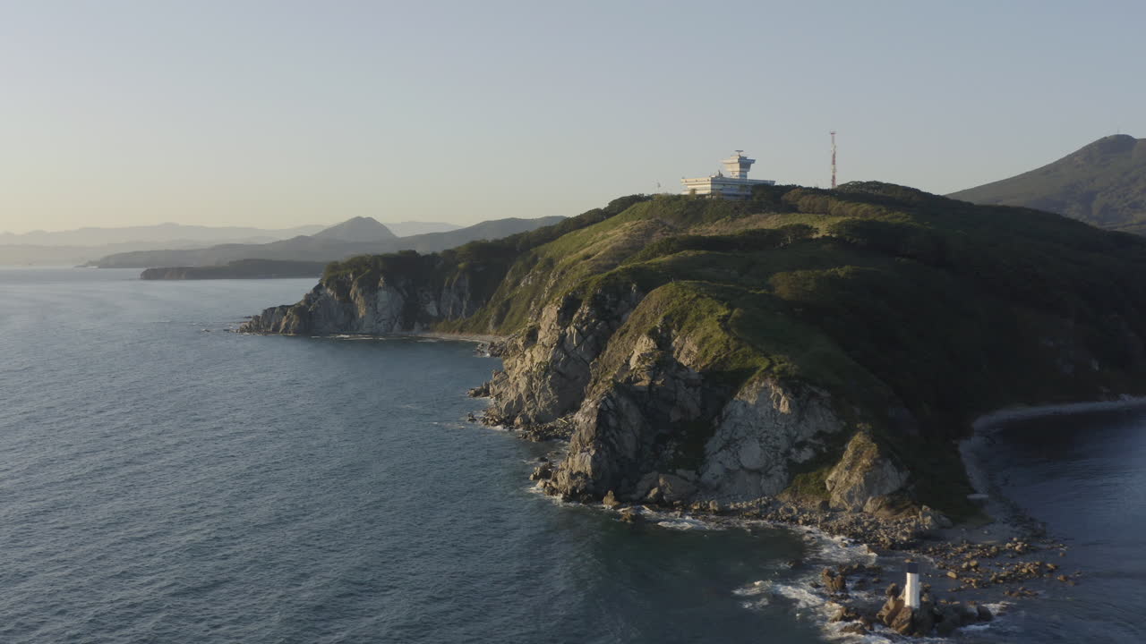 Veduta aperta di un paesaggio costiero con scogliere a picco e torre del Centro di Controllo del Traffico Marittimo in cima