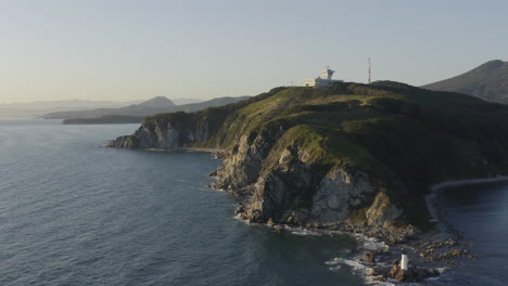 toma abierta de un paisaje costero con acantilados escarpados y una torre del centro de control de tráfico marítimo encima
