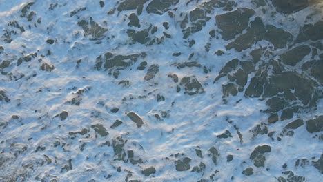 UAE:-Aerial-view-of-waves-breaks-on-the-beach,-Bird's-eye-view-of-ocean-waves-crashing-and-foaming-against-the-empty-shore,-rough-sea-view