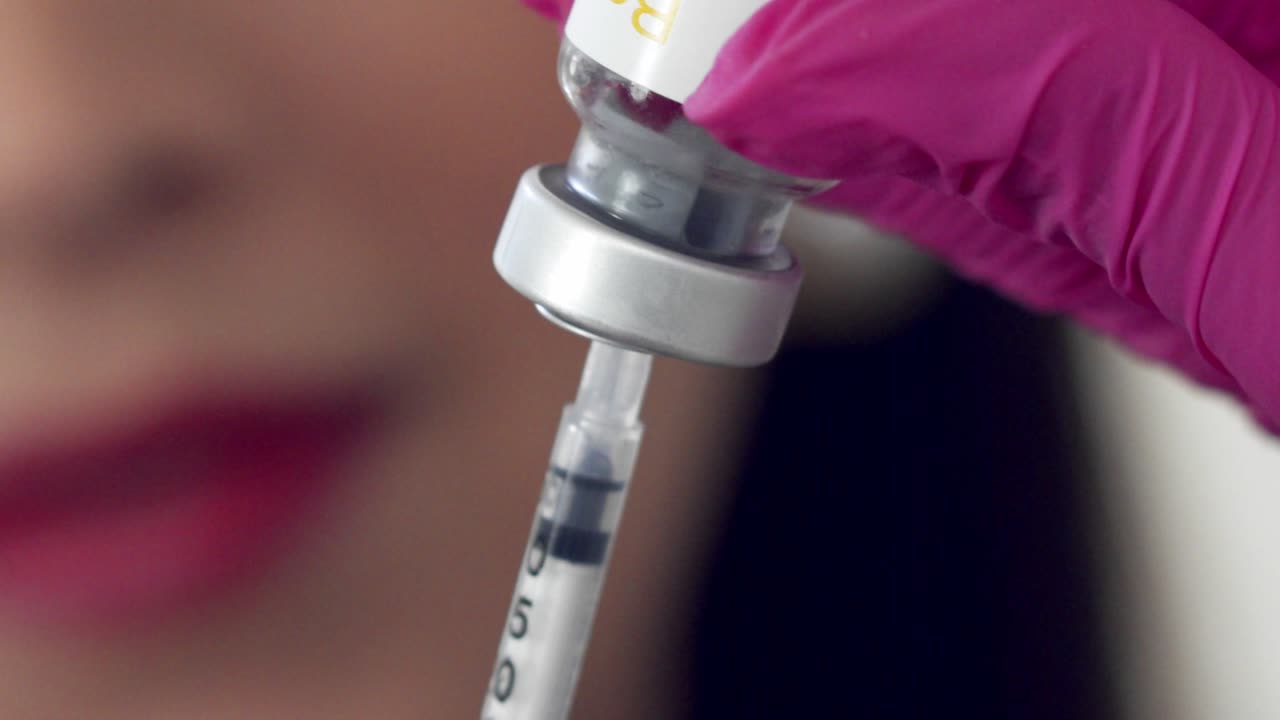 llenar una jeringa con medicamento claro para una inyección - cerrar