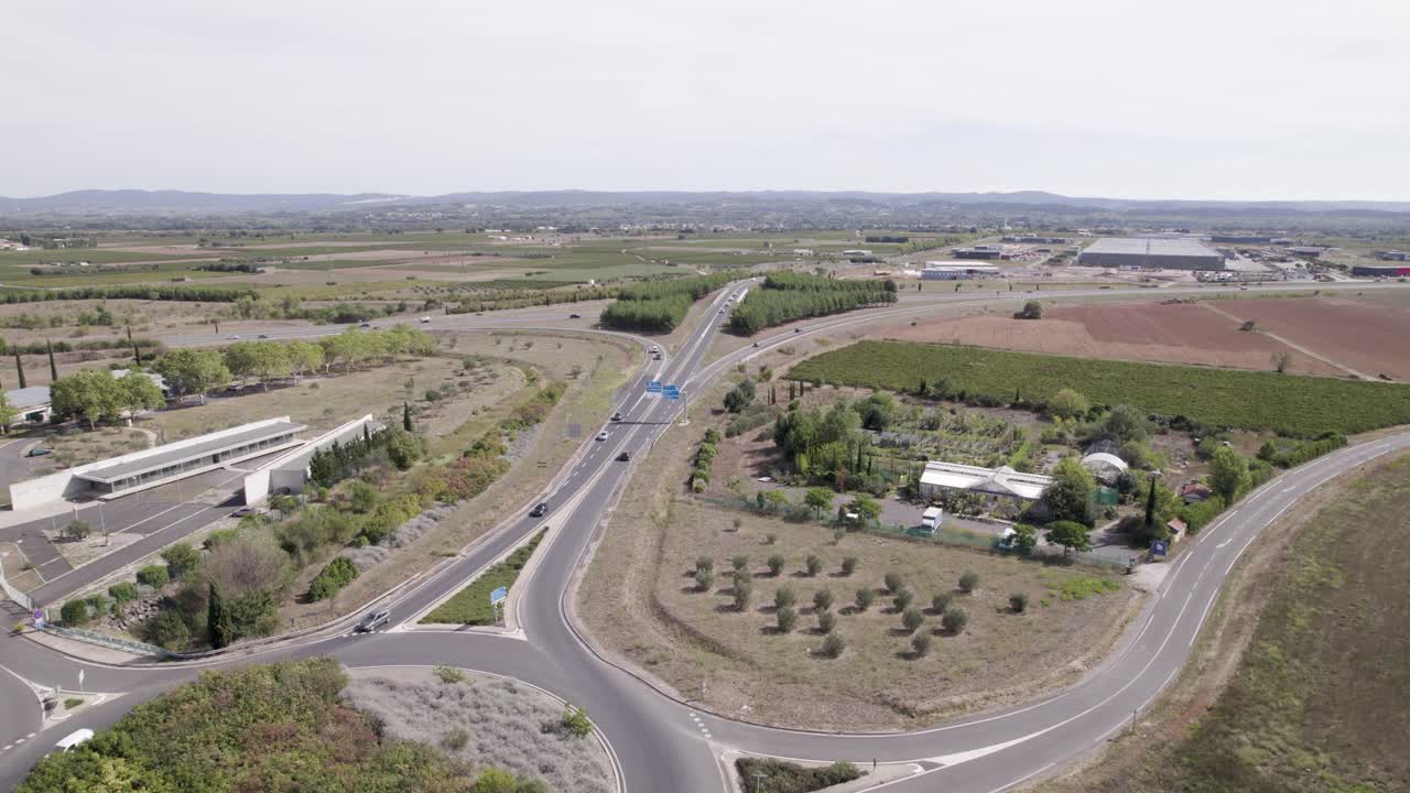 rotonda de la rotonda con automóviles en su camino para ingresar a la ciudad de clermont-l'hérault, francia, toma de aproximación aérea