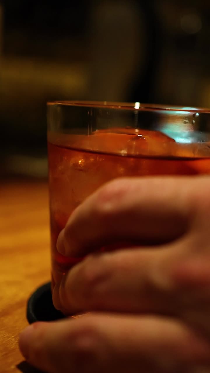 secuencia de una mano agarrando una bebida en un bar