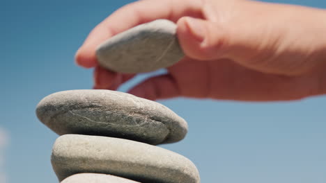 la mano pone la piedra en el video de 4k del concepto de equilibrio y equilibrio de la torre