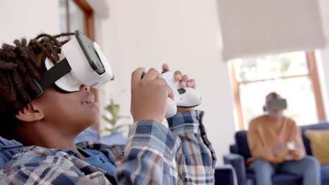 Afroamerikanischer-Vater-Und-Sohn-Spielen-Videospiele-Mit-VR-Headsets-Zu-Hause,-Zeitlupe