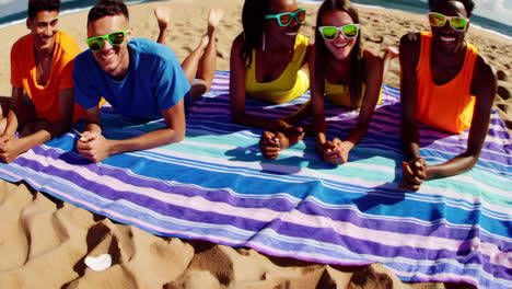 diverse group of friends relaxing on a beach blanket on a sunny day