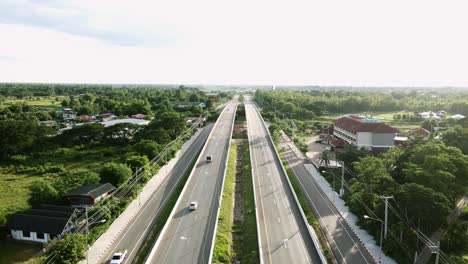 wild short of aerial view railway crossing bridge and tree forest countryside with traffic on the road in khonkaen, thailand