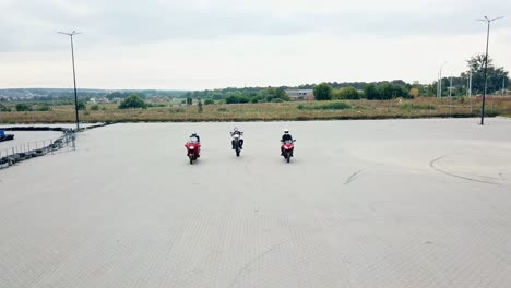 motorcycling racing outdoors. three motorbikers started racing and one of the bikers on a high speed moves first ahead.