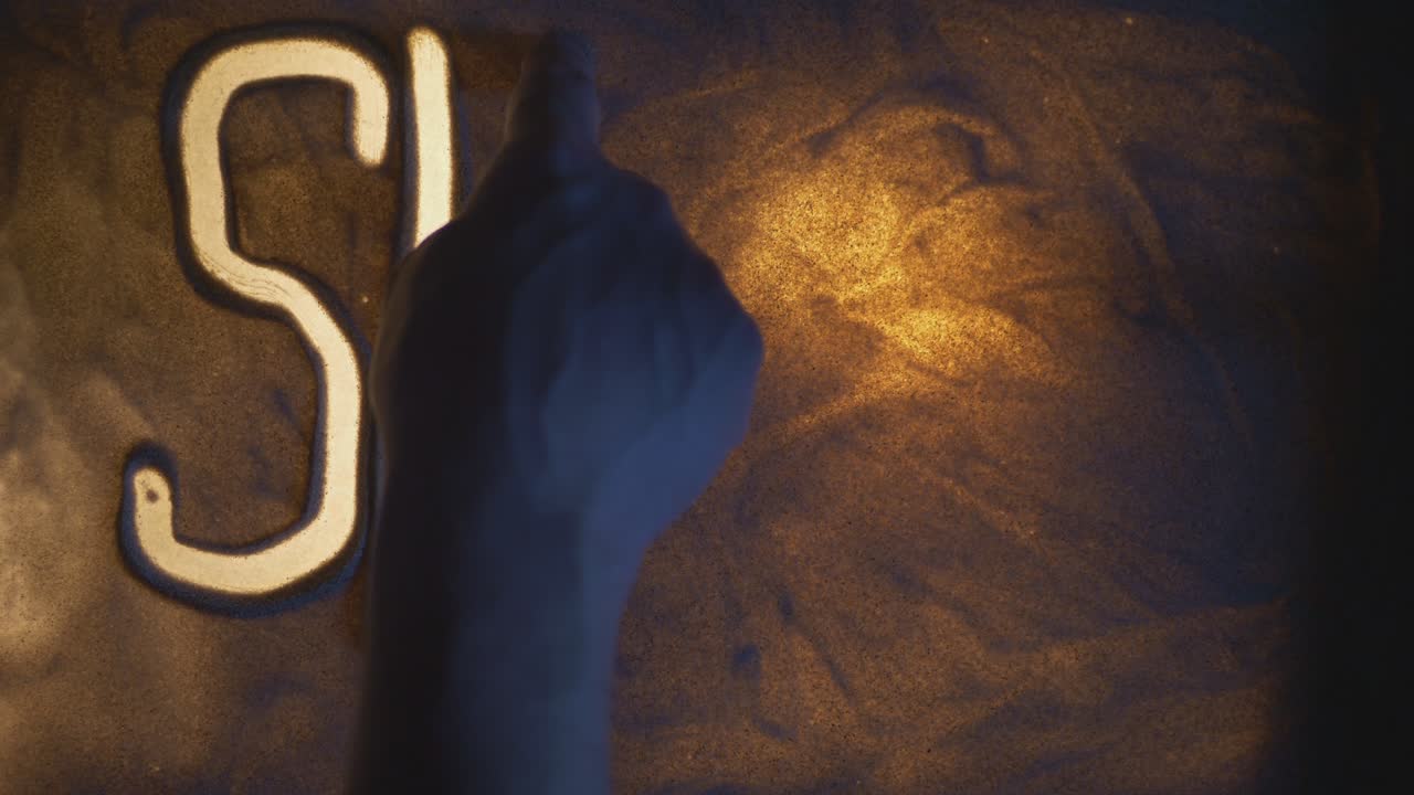 SHOW Inscription. Sand On The Illuminated Glass