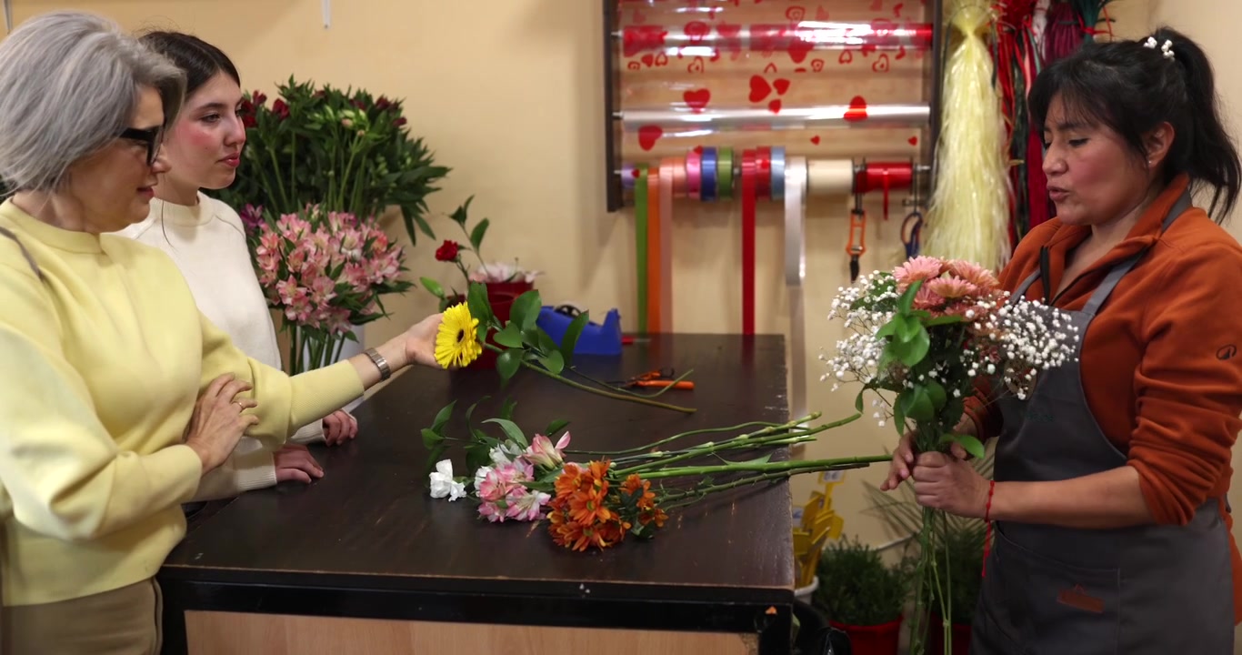 Florista arreglando un ramo para clientes en una floristería.