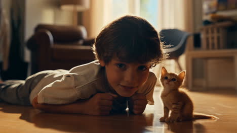 a boy and his cute ginger kitten on the floor