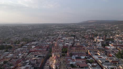 hazy cityscape skyline flyover of cathedral in san miguel, mexico