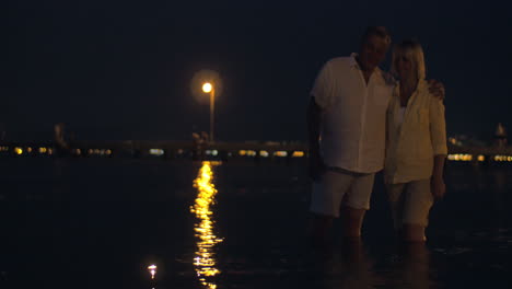 Paar-Beobachtet-Kerzen,-Die-Auf-Dem-Wasser-Segeln