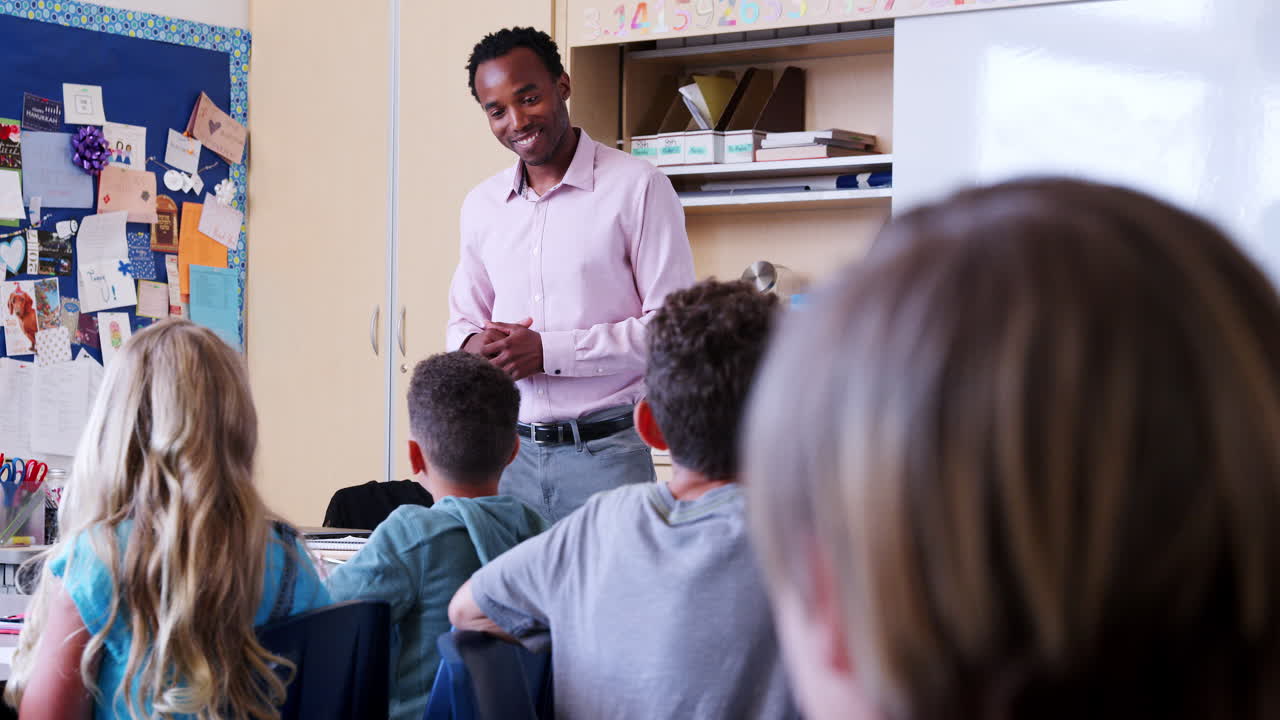 Elementary school pupils raise hands to answer teacher
