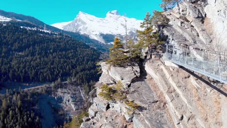 aerial view of a mountain cliff with a bridge and path