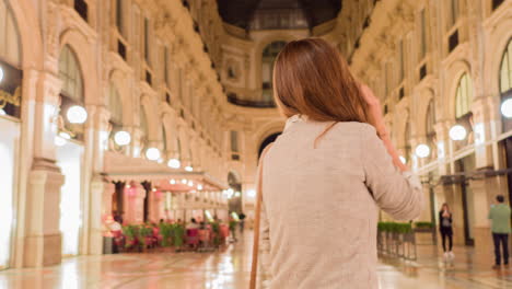 woman talking on phone in galleria vittorio emanuele ii at night