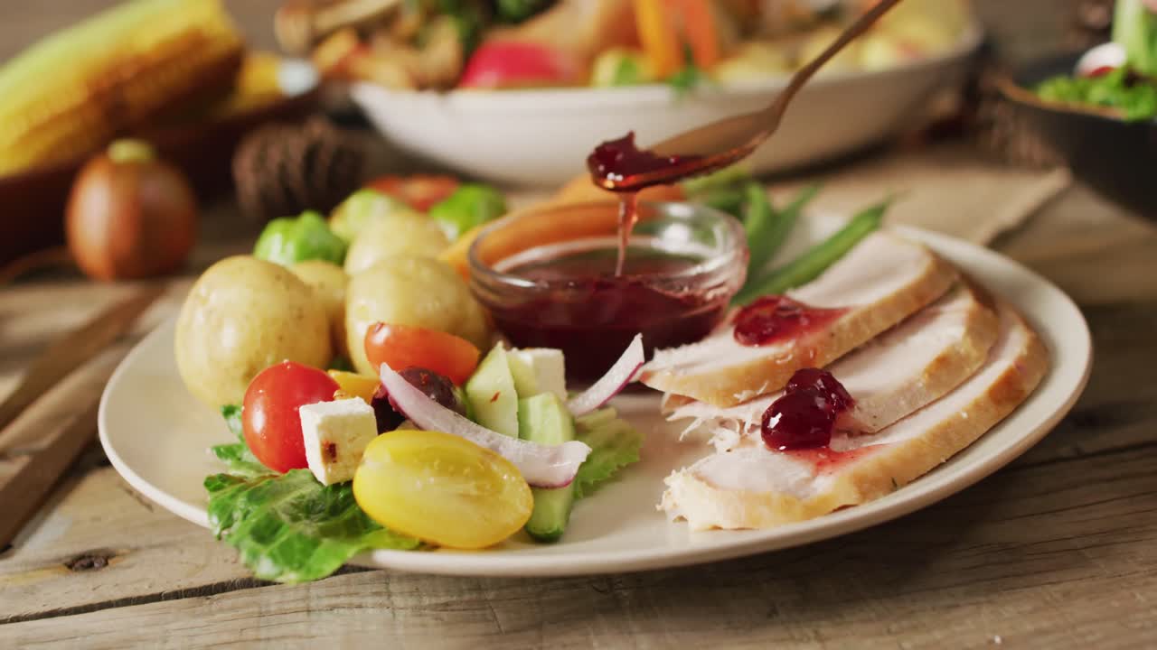 видео тарелки с картофелем, овощами и соусом на деревянном столе