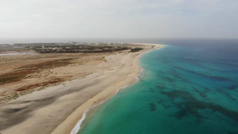 Aerial-View-Over-Beautiful-Blue-Turquoise-Ocean-Waters-Beside-Idyllic-Beach