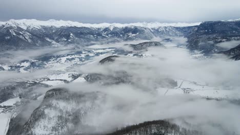 disparo de panorámica aérea cadena de montañas de invierno pico nevado día nublado