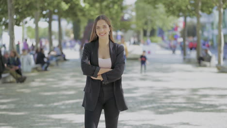 girl standing with crossed arms and smiling at camera