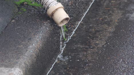 Agua-Drenando-A-Través-De-Una-Tubería-De-Drenaje-En-La-Acera-En-Tokio,-Japón---Cerrar