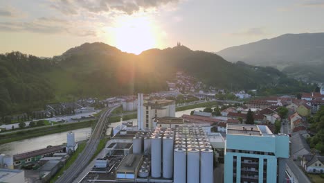 Aerial-view-over-the-Laško-beer-brewery-and-village,-colorful-sunset-in-Slovenia