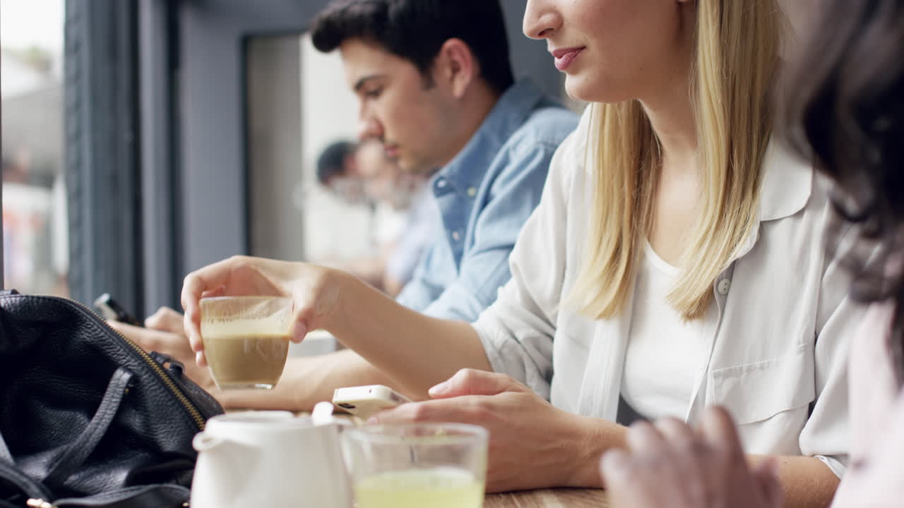 도시 카페에서 스마트폰을 사용하여 함께 공유하는 여성 친구들
