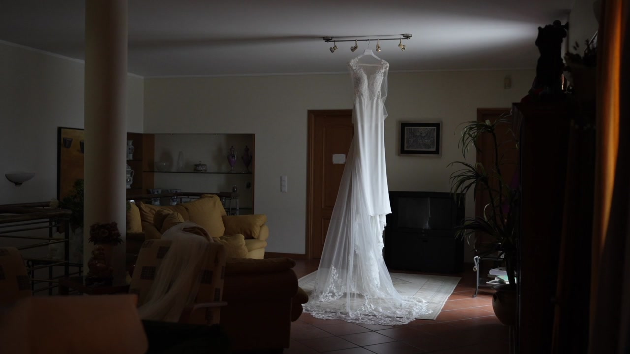 Wedding dress hanging in living room interior before ceremony