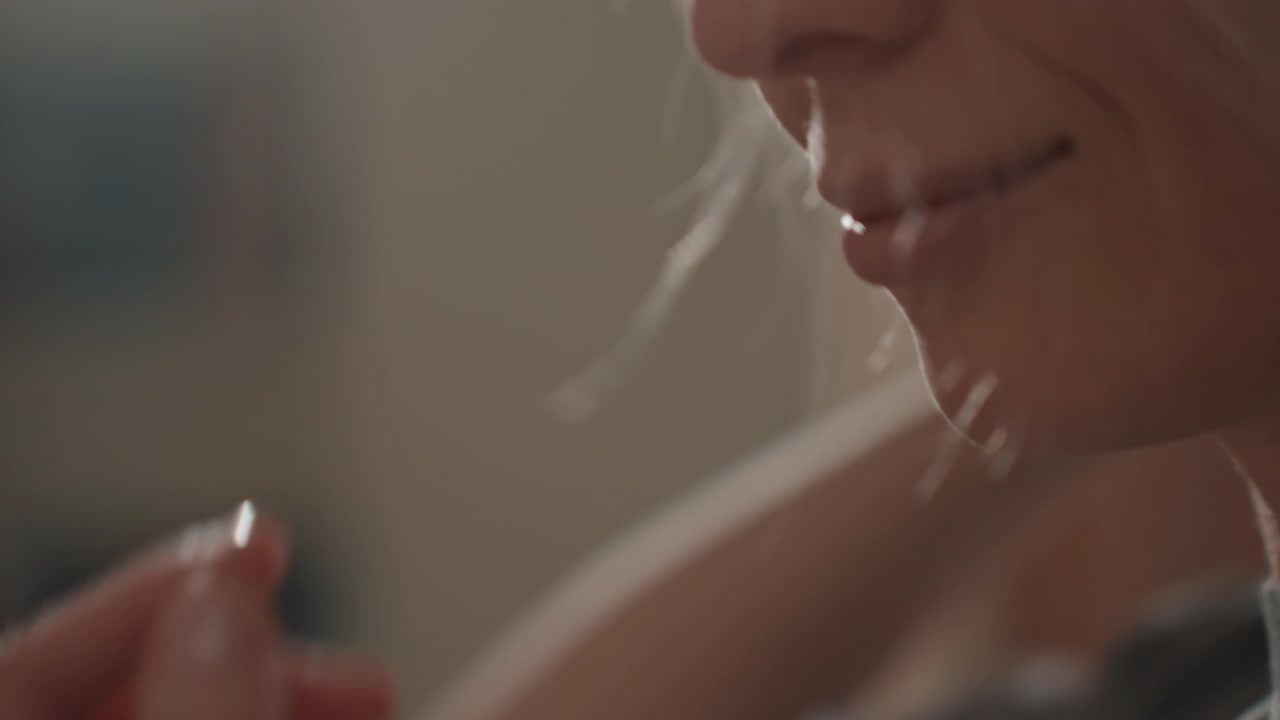 Primo piano di capelli e dettagli della spazzola che cattura ciocche morbide e setole, donna che canta teneramente in una spazzola come fosse un microfono, slow motion cinematografico, calda luce della camera da letto, umore nostalgico, rituale di cura personale.