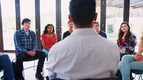 Male-Tutor-Leading-Discussion-Group-Amongst-High-School-Pupils