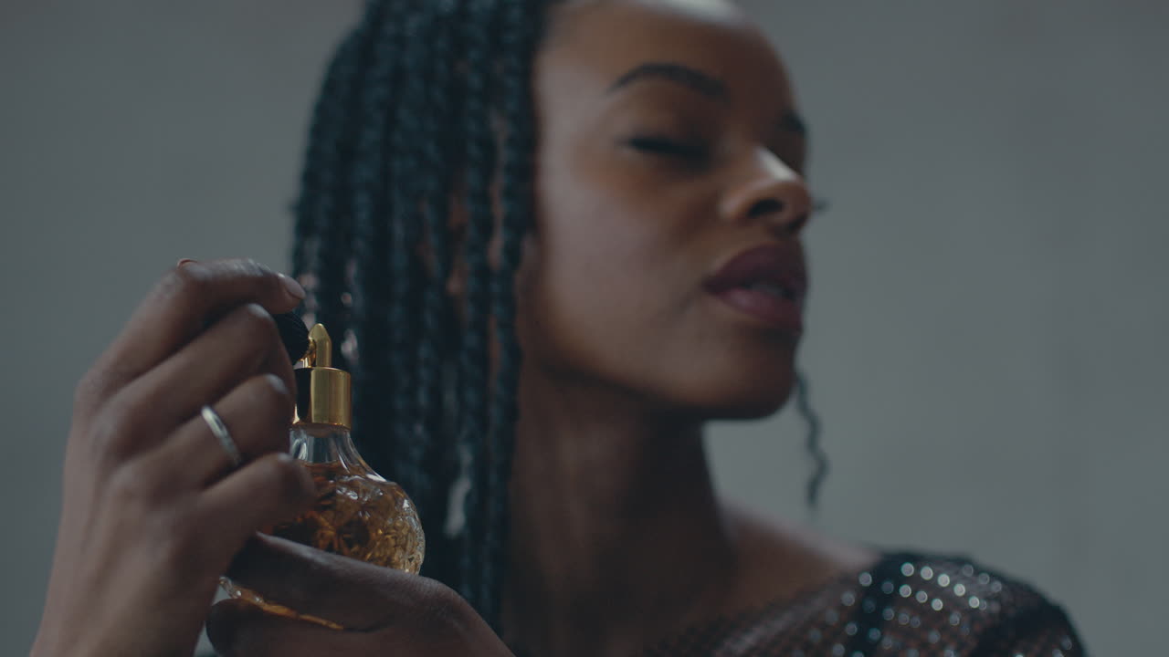 Profumo vintage spruzzato da una ragazza dalla pelle scura