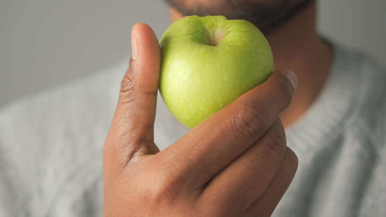 Person holding a green apple