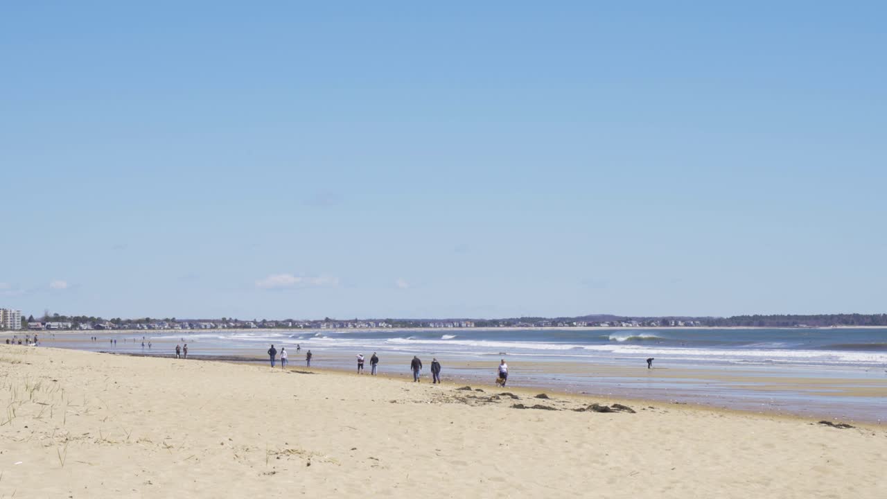 해변에서 산책하는 사람들, 코로나 바이러스 발병 기간 동안 사회적 거리를 유지하는 사람들, 넓은
