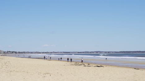 Gente-Caminando-Por-La-Playa,-Distanciamiento-Social-Durante-El-Brote-De-Coronavirus,-Amplio