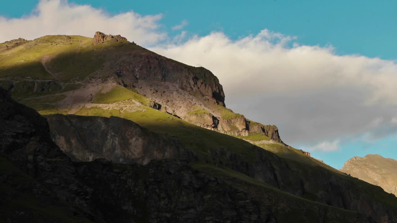 태양은 잔디와 바위로 덮인 언덕에서 움직입니다.
